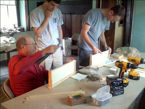 People building frames to hold the bee hives.