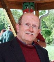 image of peter choate in red turtleneck and blue blazer