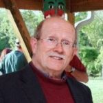 image of peter choate in red turtleneck and blue blazer