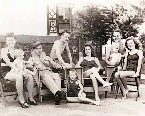 3 women and 2 boys in bathing suits plus 3 babies sitting around Al Schmidt 2nd from left in USMC uniform 