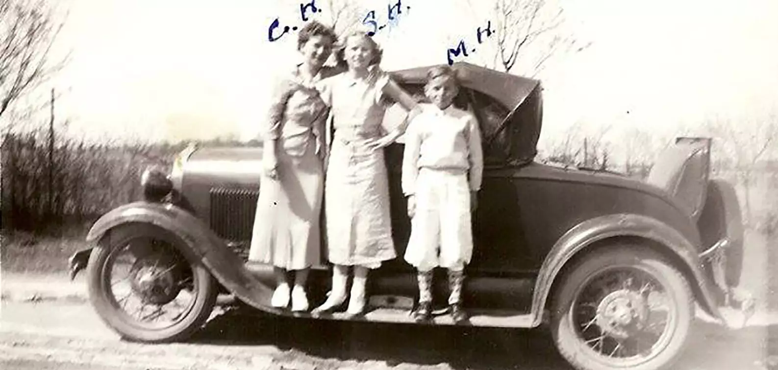 photo of Sophia Halata (Sue Bibus) in center with sister on left and brother on right standing on running board of car