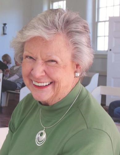 A smiling portrait of Mary Jane Clemmer wearing a green turtleneck and silver jewelry