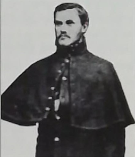 A vintage black and white portrait of Robert Kenderdine in a mid-19th-century military overcoat.